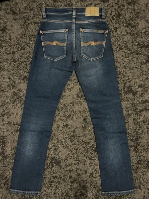 Nudie Grim Tim - Tjena! Säljer nu ett par feta Nudie jeans med en skitsnygg tvätt, det står att den är i storlek 25/28 men jag skulle säga att dem sitter som 28/30. Modellen är Grim Tim och dem sitter slimfit. Nypris på dessa är ca 1600 och jag säljer för endast 449. Jeansen är i väldigt bra skick, kom gärna med frågor och priset är ej hugget i sten!
