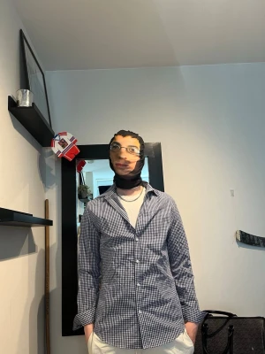 Blårutig skjorta i bomull - Klassisk blårutig skjorta med lång ärm och knappar framtill. Skjortan har en smal krage och är tillverkad i mjuk bomull, perfekt för en avslappnad men ändå stilren look. Passformen är normal och mönstret är smått rutigt i blått och vitt. Modellen är 182 cm och väger 75 kg 