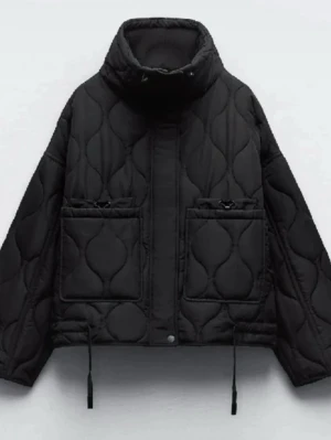 quiltad jacka från Zara - Stilren svart jacka med hög krage och två stora framfickor. Jackan har ett quiltat mönster, dragsko i nederkant och tryckknappar framtill. Storlek S från Zara