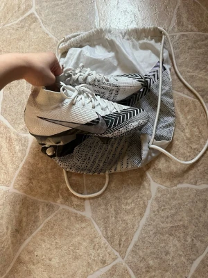 Nike Mercurial Superfly fotbollsskor - Snygga Nike Mercurial Superfly fotbollsskor i vitt med svarta detaljer och mönster. De är använda ca 2 gånger . Storlek 38,5
