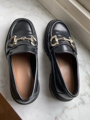 Svarta loafers med gulddetaljer - Säljer mina fina Svarta loafers med gulddetaljer, storlek 37.                                                                        I nytt skick!💗