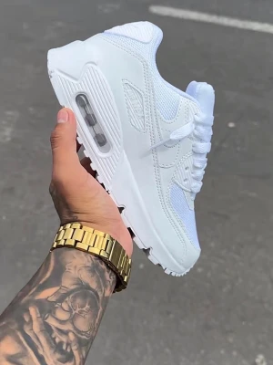 Nike Air Max 90 vita och svarta sneakers - Nike Air Max 90 sneakers i helvitt och helsvart utförande. Skorna har en klassisk siluett med synlig Air Max-dämpning i sulan, mesh och läderdetaljer samt tydliga swoosh-loggor på sidorna. Perfekta för dig som gillar stilrena och tidlösa sneakers.