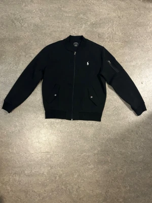 Svart bomberjacka/kofta från Ralph Lauren - Svart kofta/bomberjacka från Polo Ralph Lauren, i storlek M, nypris ca 2300 kr
