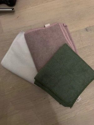 Flerfärgade mikrofiberdukar - Tre mikrofiberdukar i olika färger: grön, rosa och vit. Perfekta för städning eller rengöring hemma. Tillverkade av 100% polyester och har en mjuk, följsam känsla. Smidiga att använda i köket, badrummet eller till elektronik. Oanvända men tvättade, endast legat nedpackade men nu är det flytt på g!🫣