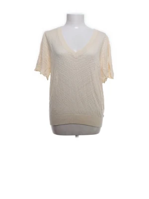 Stickad cremefärgad topp med V-ringning - Säljer en cremefärgad stickad topp med korta ärmar och djup V-ringning. Tröjan har ett diskret hålmönster och bred ribbad kant nedtill. Perfekt för lager på lager och ger en avslappnad men ändå stilren look.