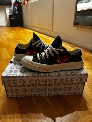 Converse x CDG Play svarta låga - Svarta Converse x Comme des Garçons Play. Väldigt bra skick! Storlek 41,5 passar 42. Helt galet snyggt med de klassiska svarta låga.