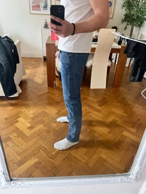 Blå jeans från Lee - Snygga blå jeans från Lee med klassisk femficksdesign och knappgylf. Perfekta för en avslappnad stil. De har en rak passform och är tillverkade i slitstarkt denim.