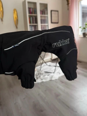 Rukka hundoverall - Säljer en helt ny hundoverall från rukka, köpt för 719kr, men passade tyvärr inte min hund och tog inte kvitto så fick inte lämna tillbaka tyvärr.  Köpt på arken zoo (storlek 25)   BESKRIVNING  Varm och vädertålig hundoverall med mjukt foder. Skyddar mot kyla, vind och väta. Justerbar passform och reflexdetaljer.  Fördelar med Rukka Thermal Hundoverall 2.0:  Varmt och mjukt plyschfoder – håller hunden varm och bekväm. Vädertåligt material – vindtätt och vattenavvisande med 3 000 mm vattenpelare.