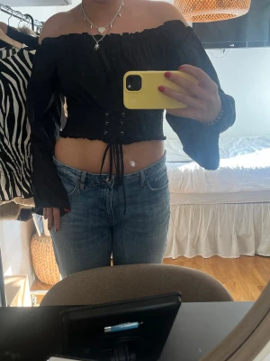 Svart offshoulder topp - Trendig svart offshoulder topp med långa ärmar och snörning framtill i midjan.