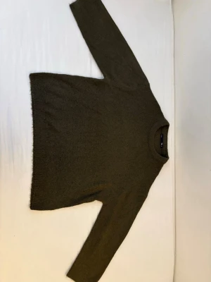 Olivgrön stickad tröja Lager 157 S men passar som M - Mysig olivgrön stickad tröja från 157 med rund halsringning och ribbade muddar. Tröjan har en enkel, avslappnad passform och är perfekt för lager på lager. Materialet känns mjukt och värmande, perfekt för kyligare dagar.
