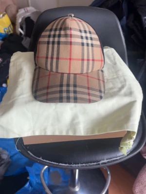 Burberry keps med klassiskt rutmönster - Snygg keps från Burberry med det ikoniska beigea rutmönstret och svarta mesh-paneler på sidorna. Perfekt accessoar för att lyfta din streetwear-look. Justerbar baktill för bästa passform. Materialet är en mix av bomull och polyester.