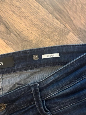 Mörkblå slim fit jeans Replay - Snygga mörkblå slim fit jeans från Replay, modell Anbass. Jeansen har klassisk femficksdesign, smal passform och stretchigt material för extra komfort. Perfekta för en trendig och avslappnad look.