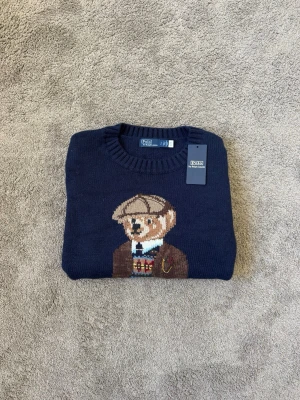 Mörkblå stickad tröja Polo Bear - Hej! Säljer nu denna Mörkblå stickade tröja från Polo Ralph Lauren med en klassisk bear på tröjan. Den är endast testad, storlek S. Passar perfekt till en mysdag och till en stilren look. Vid frågor eller funderingar hör av dig mvh 😁