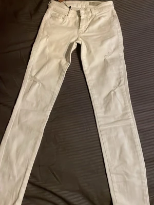 Vita skinny jeans Diesel Slandy-Ankle - Säljer ett par vita super slim skinny jeans från Diesel, modellen Slandy-Ankle. Jeansen har regular midja och stretchigt material som sitter tajt hela vägen ner till ankeln. Perfekta för dig som gillar en clean och modern look.