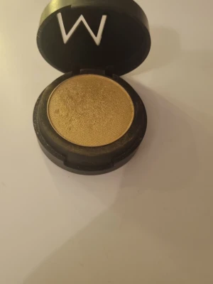 Guldig ögonskugga från Make Up Store - Snygg guldig ögonskugga från Make Up Store i rund dosa. Skuggan har en metallisk finish och är perfekt för att skapa en glammig look. Kommer i en svart förpackning med tydlig M-logga på locket.