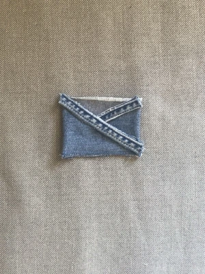 Handgjord plånbok i denim - Unik plånbok sydd av blått denimtyg med synliga råa kanter och kontrastsömmar. Plånboken har ett kuvertformat lock och är perfekt för dig som gillar en kreativ och personlig stil. Passar för kort och sedlar. Plånboken är gjord av vårat uf företag deni_mdesigm.