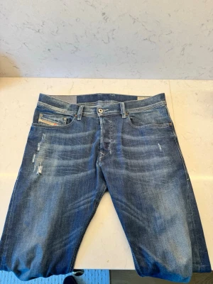  jeans från Diesel - Säljer ett par blå jeans från Diesel med snygga slitningar och tvättade detaljer. Storlek 30/32