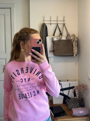 Rosa sweatshirt från Gina Tricot - Säljer en ljusrosa sweatshirt från Gina Tricot med tryck i mörkblått framtill. Tröjan har rund halsringning, ribbade muddar vid ärmslut och nederkant samt en mjuk insida. Perfekt för en avslappnad och trendig look.