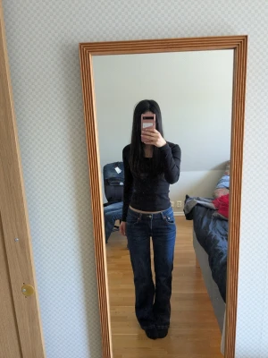 Bootcut jeans från 157, mörkblå - Säljer ett par mörkblå bootcut jeans från 157 med klassisk 90-talsstil. Jeansen har låg midja, utsvängda ben och tydliga kontrastsömmar. Perfekta för dig som gillar retrovibbar och en avslappnad look.