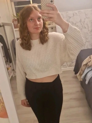 Vit cropped stickad tröja - Säljer en vit, stickad cropped tröja med stickat mönster och långa ärmar. Tröjan har ribbade muddar vid ärmslut och nederkant. Skriv vid intresse❤️