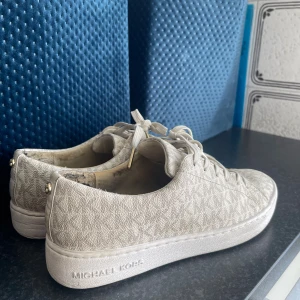 Beige Michael Kors sneakers med monogram - Snygga beige sneakers från Michael, storlek 38 men kan användas som 39 också