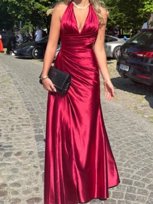 Vinröd(ish) Balklänning - Snygg vinröd långklänning i glansigt satinmaterial med halterneck och djup v-ringning. Klänningen har figurnära passform upptill och faller elegant nedtill. Perfekt för bal eller festliga tillfällen. Endast använt två gånger❤️❤️Pris kan såklart diskuteras 