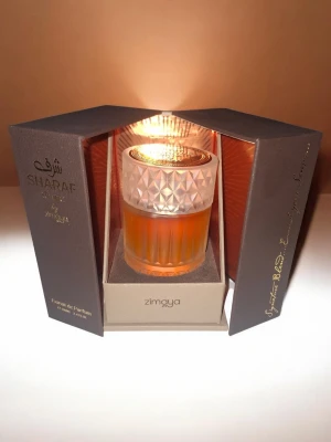Sharaf Divine från Zimaya - Toppnoter: kaffe, cognac/boozy toner, kryddor Hjärtnoter: choklad, tonka, tränoter Basnoter: vanilj, pralin, amber, mysk