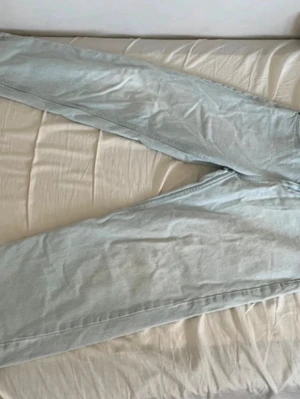 Ljusblå baggy jeans från FSBN - Säljer ett par ljusblå baggy jeans från FSBN. Jeansen har en avslappnad passform och klassisk femficksdesign. Tillverkade i denim med snygg tvättad look och metallknapp med FSBN-logga. Perfekta för en chill och trendig stil.