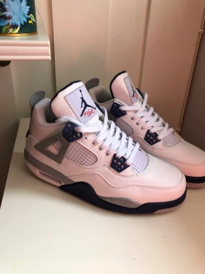 Air Jordan 4 midnight navy - Snygga Air Jordan 4 Retro sneakers i vitt läder med marinblå och grå detaljer. Klassisk siluett med meshpaneler, plastdetaljer och Jumpman-logga på plösen. Perfekta för dig som gillar streetwear och ikoniska sneakers.