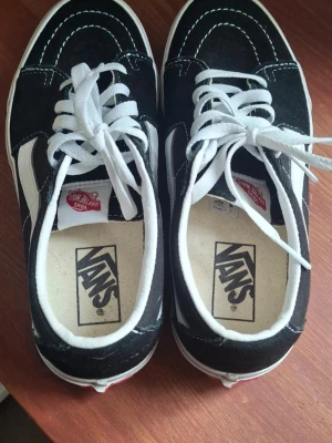 Svarta Vans Old Skool sneakers endast använda 2 ggr pga fel storlek. - Klassiska Vans Old Skool sneakers i svart mocka och canvas med vita detaljer och vit sula. Skorna har den ikoniska vita sidostripen, vita skosnören och Vans-logga på hälen. Perfekta för en avslappnad streetwear-look.