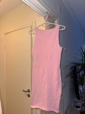 Rosa ärmlös klänning Gina Tricot - Säljer en enkel och snygg rosa kortklänning från Gina Tricot. Klänningen är ärmlös med rund halsringning och har en tight passform. Perfekt för dig som gillar en stilren look och mjukt material.