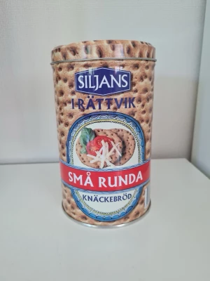 Plåtburk Siljans knäckebröd - Fin plåtburk med Siljans små runda knäckebröd-motiv. Cylindrisk burk med lock, bra som förvaring i köket.