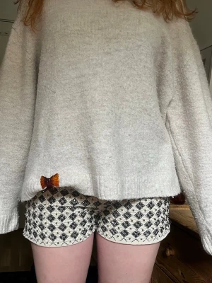 Mönstrade shorts från H&M - Snygga shorts från H&M med svartvitt rutigt mönster och glittriga detaljer. De har en klassisk passform och är fodrade med ett silkeslent tyg. Perfekta för dig som vill sticka ut lite extra i sommar!