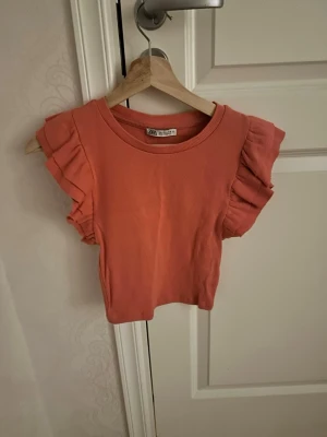 Zara topp  - En korallfärgad, fin volangtopp från Zara i storlek XS. Varan är liten i storlek. Priset kan diskuteras.