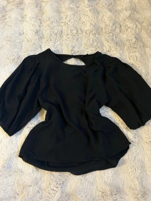 Svart blus med öppen rygg - Svart blus med snygg öppen ryggdetalj.