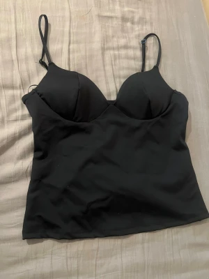 Svart topp från Gina tricot - Svart topp från Gina tricot i storleken M. Aldrig använd innan, säljer då den inte passa i storlek!
