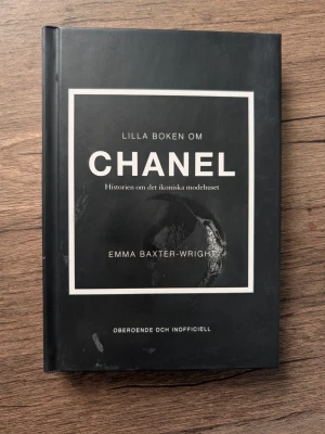 Lilla boken om Chanel - En snygg och stilren bok med svart hårdpärm och vit text, skriven av Emma Baxter-Wright. Boken berättar historien om det ikoniska modehuset Chanel och är perfekt för dig som gillar mode och design.