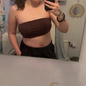 Brun bandeau topp från Gina Tricot - Säljer en brun bandeau topp i mjukt bomullstyg i storlek Medium, från Gina Tricot. Den har en elastisk kant upptill som hjälper toppen att sitta på plats och minskar risken att den glider ner. Är välanvänd och möjligtvis lite uttöjd till och med. Säljes pga att jag har fått större bröst så den är för liten för mig🤩☺️