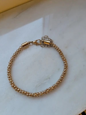 Guldigt pärlarmband med kedjedetalj - Snyggt armband i guldfärgad metall med små pärlor som ger en glittrig effekt. Perfekt för att lyfta outfiten🌸