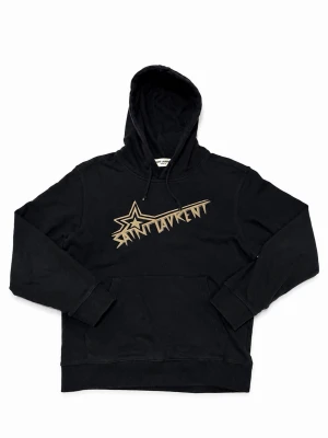 Saint Laurent hoodie  - Svart hoodie från Saint Laurent med beige grafiskt tryck och stjärndetalj på bröstet. Klassisk känguruficka framtill och justerbar huva med snören. Tillverkad i mjukt material som känns skönt mot huden. Perfekt för en avslappnad och trendig look.