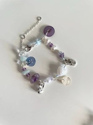 Maximalist armband lila - Handgjort armband i silver med blå och lila pärlor. Det är unikt och gjort med återbrukade knappar! Skriv vid fler frågor och funderingar💞
