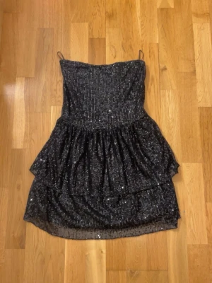Svart glittrig kort klänning - Säljer min svarta glitter klänning från Gina Tricot i storlek Xs använd en gång💕