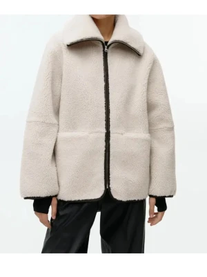 Beige teddyjacka med dragkedja - Mysig beige teddyjacka med oversized passform och hög krage. Jackan har svarta detaljer längs dragkedjan och muddar, samt stora fickor framtill. Tillverkad i mjukt teddy-material som ger en cool och avslappnad look.