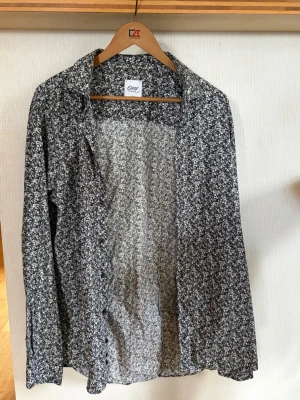 Svartvit skjorta Oscar of Sweden - Säljer en slim fit skjorta från Oscar of Sweden i storlek 44. Skjortan är svartvit och har knappar framtill. Perfekt för dig som gillar stilrena och unika plagg med lite edge. Passar perfekt till sommaren eller att ha under din kavaj för att få en snyggare look. Skjortan är heller aldrig använd så helt ny bara utan prislapp. Priset kan sänkas vid snabb affär och fraktar bara genom PostNord. Vid mer frågor så hör ni av er.