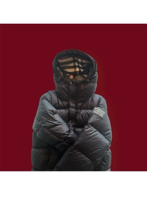 Svart dunväst från Burberry - Snygg svart dunjacka som man kan göra till väst från Burberry med klassiskt rutigt foder i huvan. Västen har dragkedja och knappar framtill samt två fickor med dragkedja. Perfekt för lager-på-lager och ger en cool streetwear vibe.