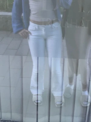 Vita raka jeans med hög midja - Säljer ett par vita jeans med bot passform och medel midja. Jeansen har klassisk femficksdesign och stängs med dragkedja och knapp. Perfekta för en fräsch och stilren look. 