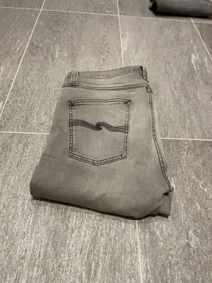 Nudie jeans - Säljer dessa snygga jeans med fräsch tvätt nu till vår/sommar. Nudie märke med svarta sömmar. Nyskick. Storlek 30/30 sitter som 30/32. Skriv vid frågor och funderingar.