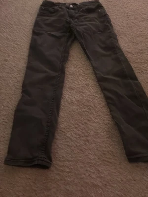 Levi's 512 Slim Taper svarta jeans - Säljer ett par svarta Levi's 512 Slim Taper jeans med klassisk femficksdesign och knappgylf. Jeansen har en smal passform som smalnar av nedtill och är tillverkade i slitstarkt denim. Perfekta för dig som gillar en modern och clean look.