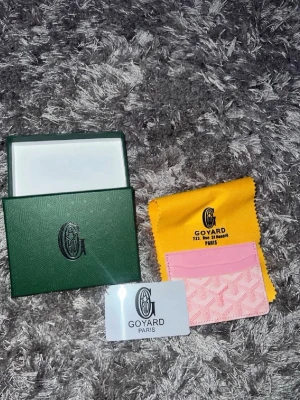 Plånbok  - Säljer ett snyggt rosa kortfodral från hm med klassiskt mönster och logga framtill. Kortfodralet har flera fack för kort och är gjort i ett tåligt material med läderdetaljer. Kommer med original ask, tygpåse och certifikat.