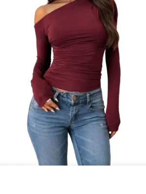 Vinröd oneshoulder topp - Trendig vinröd topp med oneshoulder-design och långa ärmar. Sitter tight och har snygga rynkade detaljer i midjan. Perfekt att styla med jeans eller kjol för en cool look. Passar Xs också för det är vad jag brukar ha i vanliga fall☺️